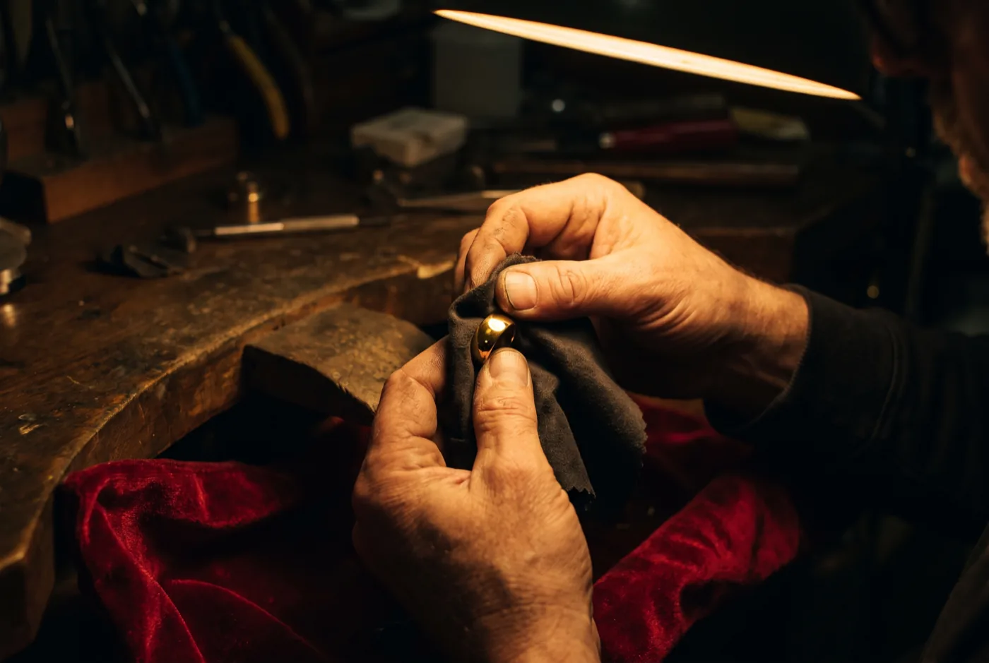 Manos dando la terminación final a un anillo de oro con un paño